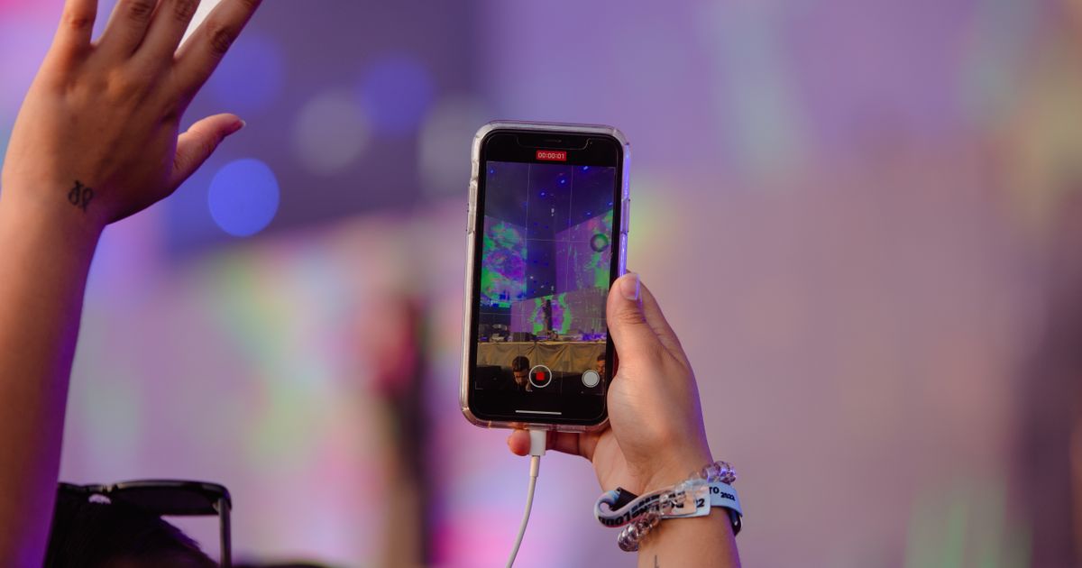 A person recording an event with a smartphone