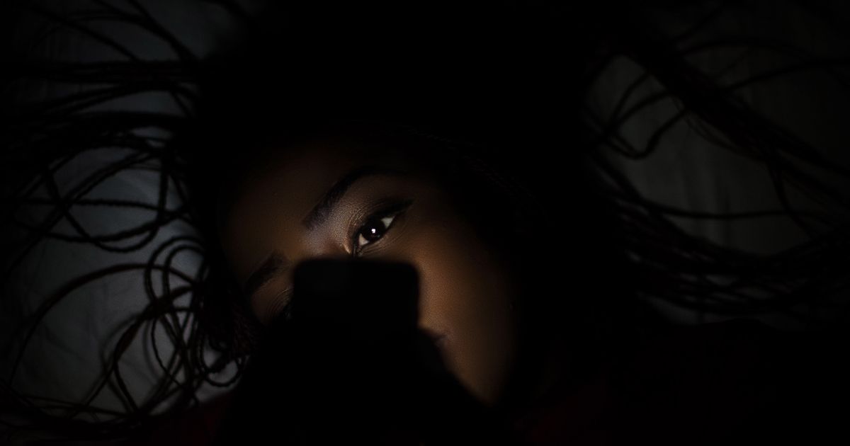 A person using a phone in a dimly lit room