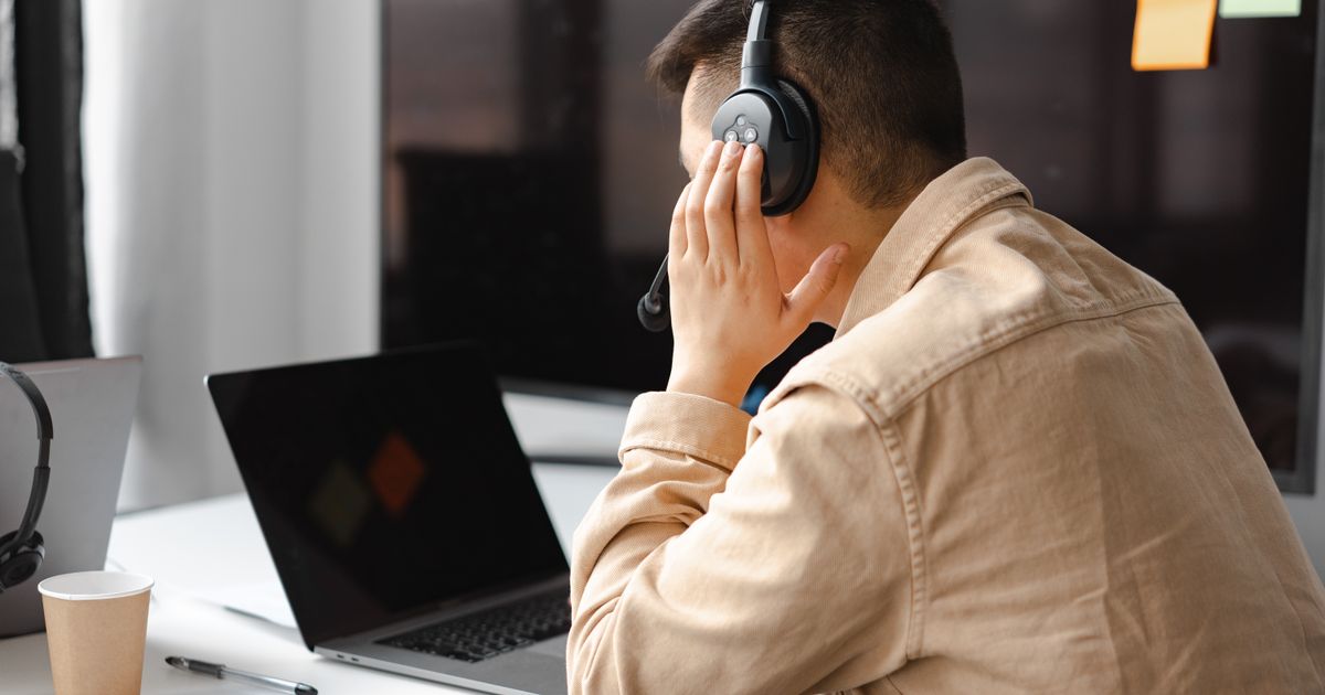 A person working at a laptop with headphones